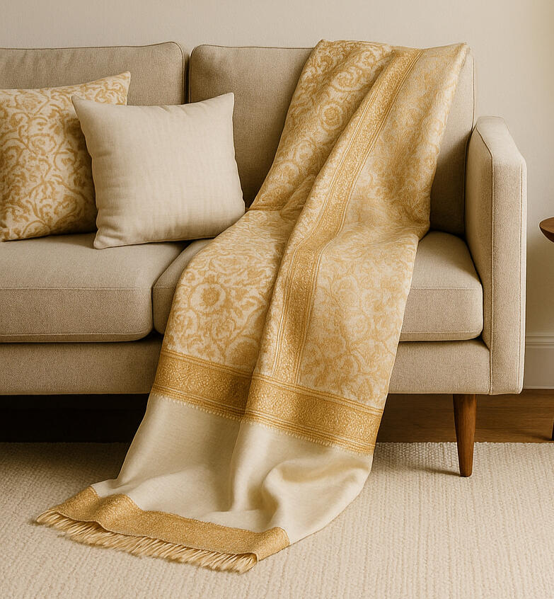Banaras Silk throw Banaras silk saree reimagined as a throw and a cushion cover placed on a living room sofa. The setting shows a blend of traditional craft in European modern home